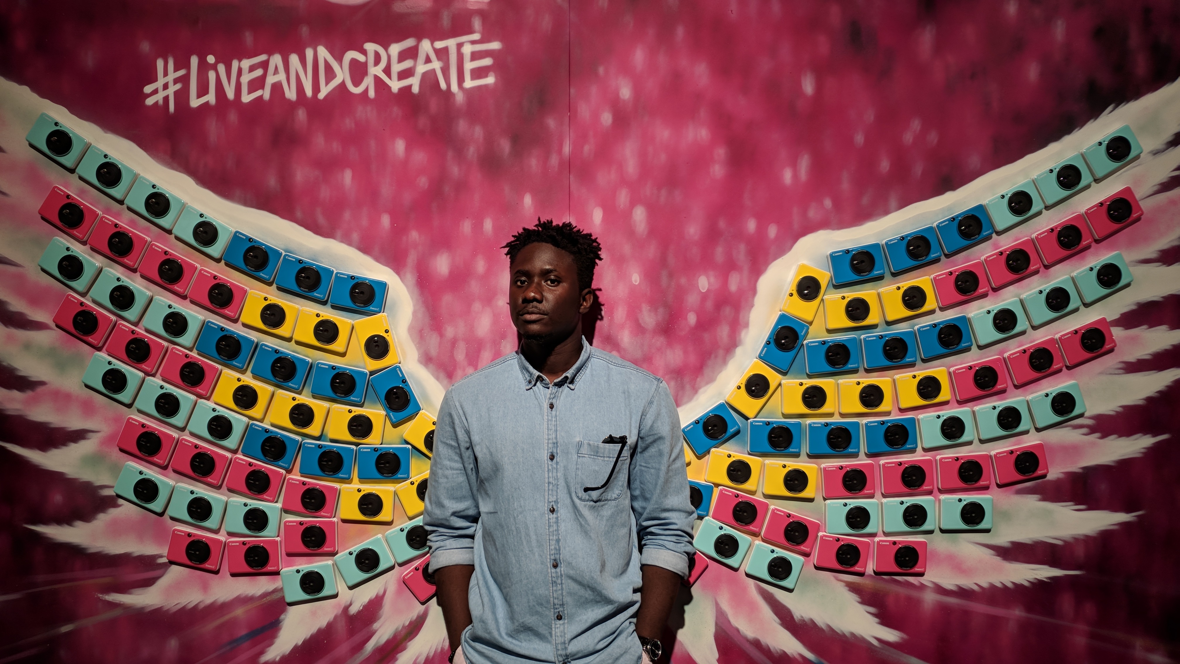 Portrait of Eyo against a mural that says #liveandcreate